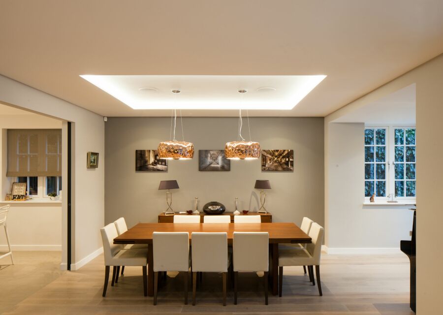 Dining room with large table with pendant lights above.